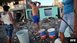 Cubanos recolectan agua el 7 de octubre de 2016, tras el paso del huracán Matthew en Baracoa (Cuba).