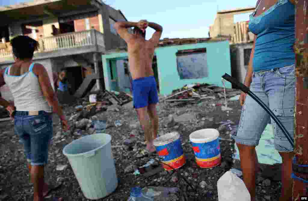 Cubanos recolectan agua hoy, viernes 7 de octubre de 2016, tras el paso hace tres días del huracán Matthew en Baracoa (Cuba).EFE/Alejandro Ernesto