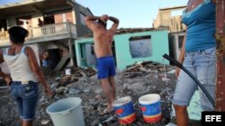 Cubanos recolectan agua hoy, viernes 7 de octubre de 2016, tras el paso hace tres días del huracán Matthew en Baracoa (Cuba).EFE/Alejandro Ernesto