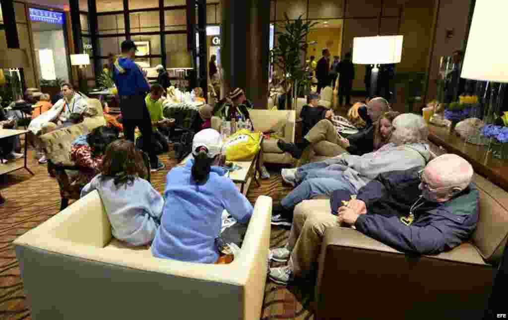 Espectadores y corredores se reúnen en un salón del hotel Westin después de que se registraran dos explosiones cerca a la línea de meta de la 117 Maratón de Boston. 