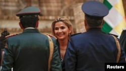 Jeanine Añez, presidenta interina de Bolivia, saluda a la cúpula militar durante una ceremonia en La Paz. 