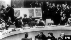 El delegado norteamericano en la ONU, Adlai Stevenson, muestra a los miembros del Consejo de Seguridad, las fotos aéreas de las bases rusas de cohetes en Cuba. Stevenson aparece a la derecha de la foto; a la izquierda, el delegado ruso, Valerian Zorin