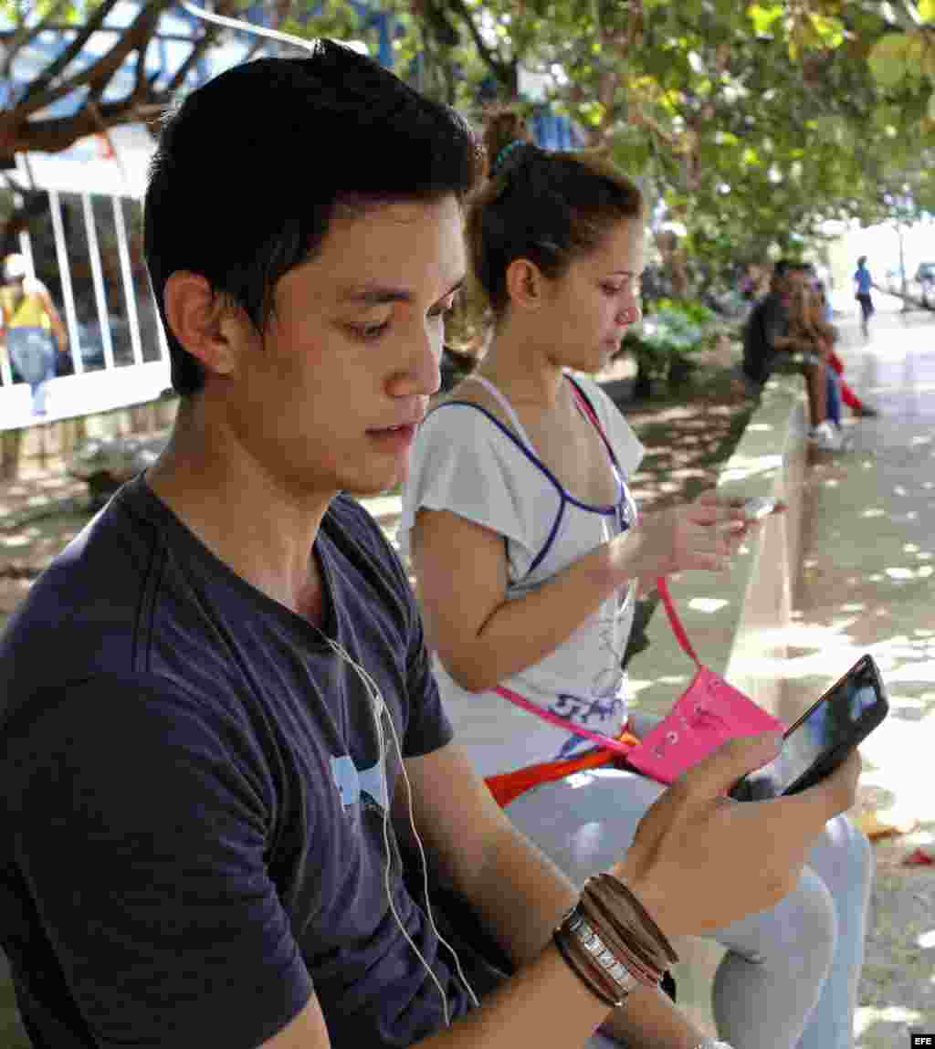 Usuarios de internet a través de un dispositivo móvil desde una de las zonas habilitadas con Wi-Fi en La Habana (3 de julio, 2015).