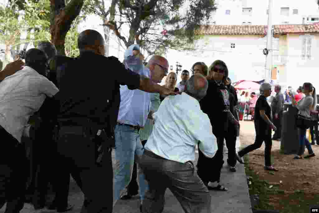 Al ventro Orlando Gutiérrez Boronat, del Directorio democrático Cubano, flanqueado por agentes de la embajada cubana en Panamá.