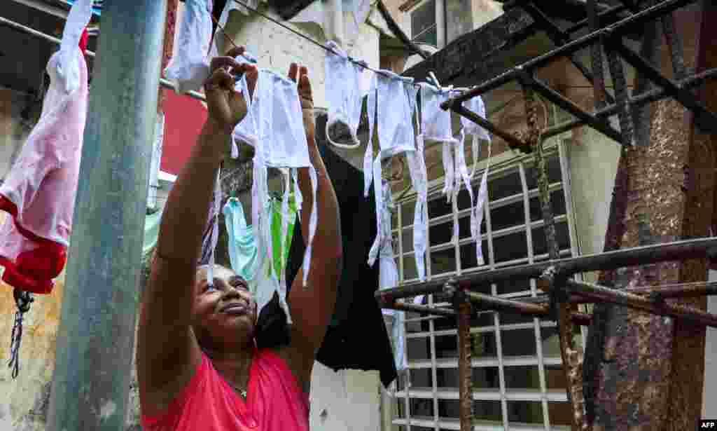 Una mujer tiende nasobucos preparados por ella misma para distribuir entre vecinos del Vedado (Foto: Adalberto Roque/AFP).