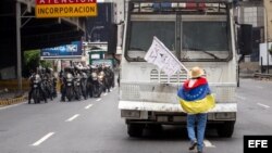 Una mujer bloquea el paso de una tanqueta de la Guardia Nacional durante una manifestación encabezada por diputados opositores hoy, miércoles 3 de mayo de 2017, en Caracas (Venezuela). La Guardia Nacional Bolivariana (GNB, policía militarizada) de Venezue