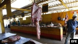 Archivo - Varios carniceros esperan la llegada de clientes en un agromercado de La Habana (Cuba). 