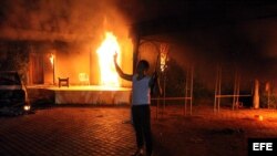 La administración Obama explicó primero el ataque en Bengazi, Libia, como una protesta "secuestrada". Luego se precisó que había sido un plan terrorista. En la foto, un atacante armado frente a las llamas.