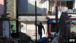 Un hombre limpia de escombros al frente de su vivienda hoy, viernes 7 de octubre de 2016, tras el paso hace tres días del huracán Matthew en Baracoa (Cuba).EFE/Alejandro Ernesto
