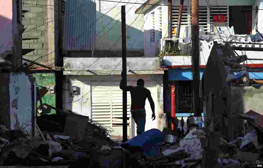 Un hombre limpia de escombros al frente de su vivienda hoy, viernes 7 de octubre de 2016, tras el paso hace tres días del huracán Matthew en Baracoa (Cuba).EFE/Alejandro Ernesto