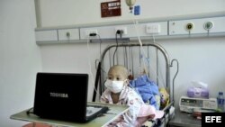 Fotografía de archivo de un niño enfermo de leucemia que ve una película a través de un ordenador portátil. 