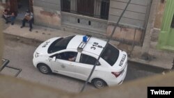 Una patrulla policial en los bajos del edificio donde vive la curadora Anamely Ramos, en La Habana. (Twitter/Movimiento San Isidro)