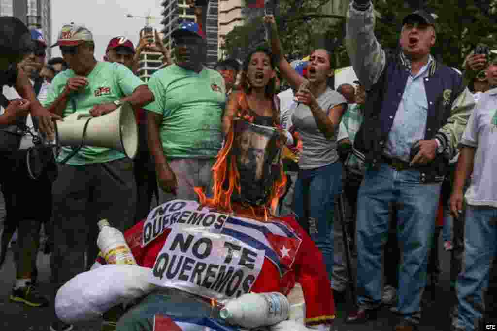 Un grupo de manifestantes quema un muñeco de trapo con la fotografía del presidente venezolano Nicolás Maduro.
