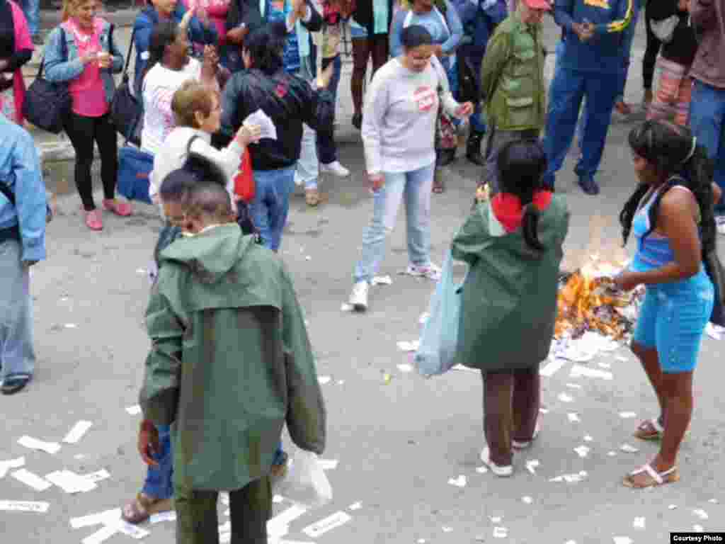 Las turbas que integran las Brigadas de Respuesta Rápida (BRR) queman volantes y ejemplares de la Declaración Universal de los Derechos Humanos que les lanzaron las Damas de Blanco en su sede de Lawton, La Habana. Foto cortesía Ángel Moya.