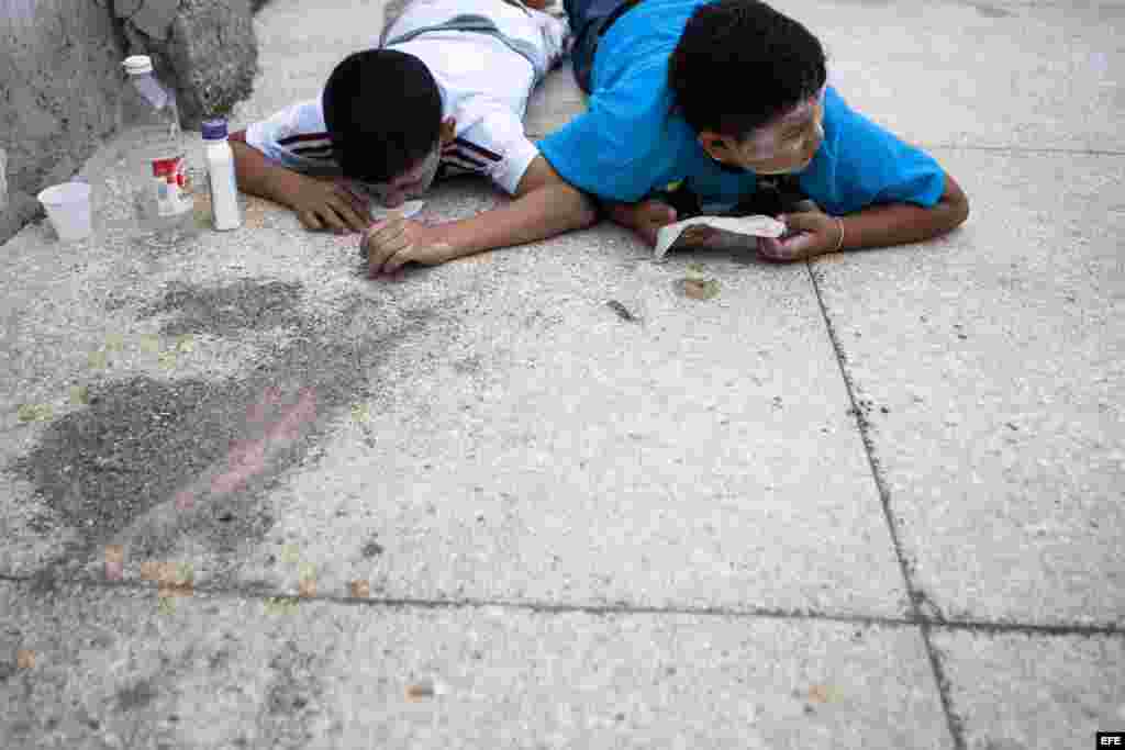 Dos niños se protegen de las bombas lacrimógenas hoy, viernes 7 de marzo de 2014, cerca de la Plaza Altamira de Caracas (Venezuela). 