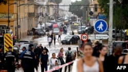 Los residentes caminan junto a autos amontonados luego de las inundaciones en el barrio De La Torre de Valencia, este de España, el 30 de octubre de 2024.