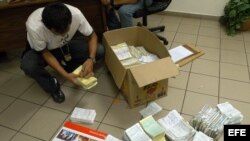 Foto de archivo. Un miembro de la Dirección General de Servicios Especiales de Investigación de Honduras revisa papeles migratorios.