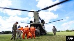 Personal de Protección Civil de Panamá y efectivos del Ejército estadounidense  descargando ayuda humanitaria transportada por un helicóptero Chinook del Comando Sur de EE. UU. en Penonomé, Panamá, el 10 de octubre de 2026.