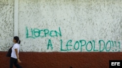 Un hombre camina junto a un muro donde aparece un grafiti pidiendo la liberación del dirigente político venezolano opositor Leopoldo López hoy, jueves 5 de junio del 2014, en el municipio de Chacao, en Caracas.