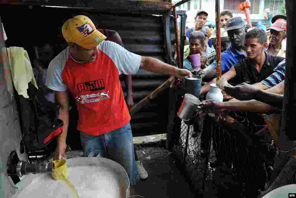 Varias personas compran cerveza en Santiago de Cuba. 