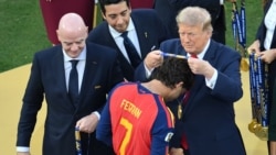 El delantero español Ferran Torres (n.º 7, en primer plano) recibe la medalla de oro de manos del presidente de la FIFA, Gianni Infantino, y del presidente de los Estados Unidos, Donald Trump (derecha)