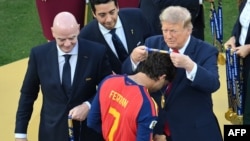 El delantero español Ferran Torres (n.º 7, en primer plano) recibe la medalla de oro de manos del presidente de la FIFA, Gianni Infantino, y del presidente de los Estados Unidos, Donald Trump (derecha)