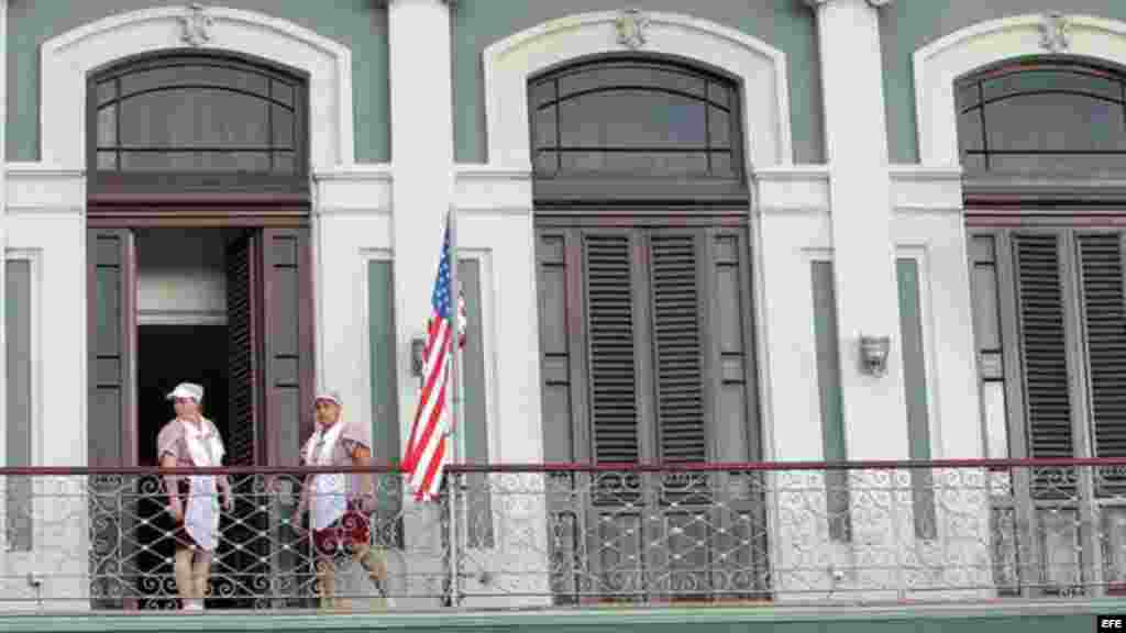 Empleadas acomodan bandera estadounidense en hotel donde llegó una comitiva de senadores de EE.UU.