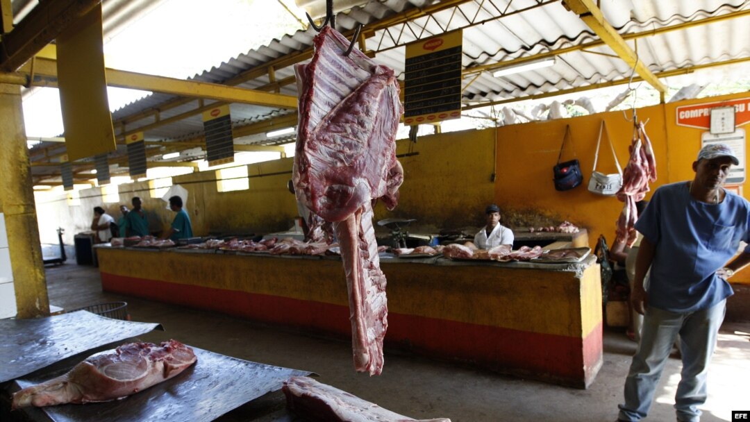 Archivo - Varios carniceros esperan la llegada de clientes en un agromercado de La Habana (Cuba). 