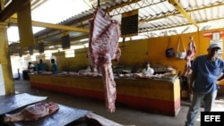 Archivo - Varios carniceros esperan la llegada de clientes en un agromercado de La Habana (Cuba). 