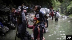 Migrantes de Haití cruzando la selva del Darién entre Colombia y Panamá, el 9 de mayo de 2023. (AP Photo/Iván Valencia).