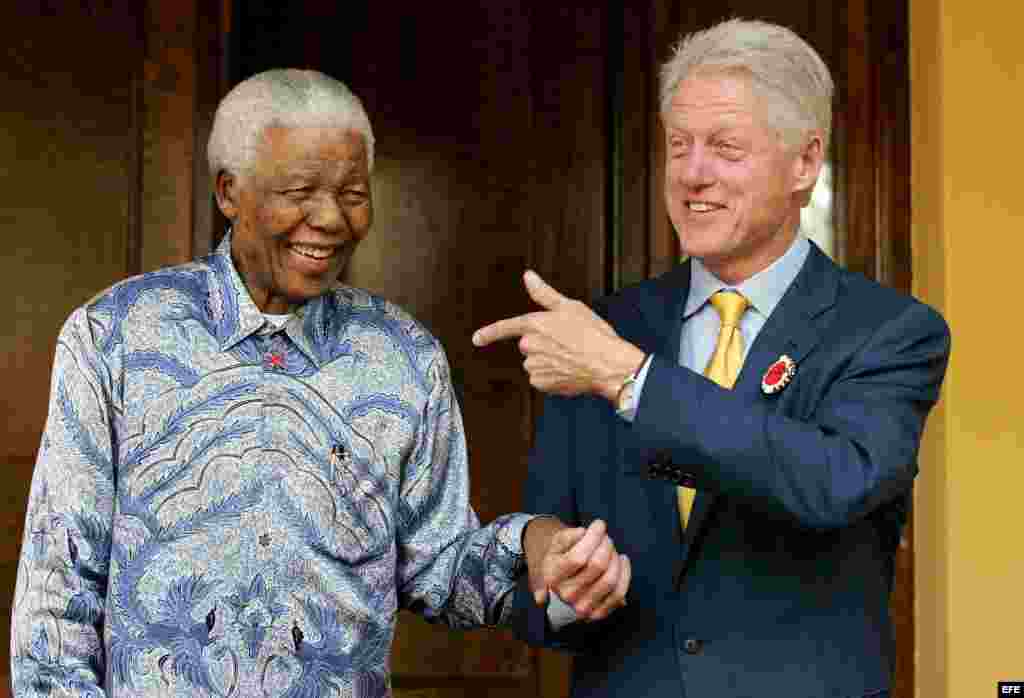 'Madiba', como se le conocía a Nelson Mandela, (i) junto al expresidente estadounidense Bill Clinton (d) mientras se ríen de un chiste en su residencia privada en Johanesurgo (Sudáfrica). 