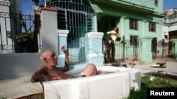 El pintor jubilado Julio Rodríguez, de 61 años, se relaja en una bañera frente a su casa en La Habana, Cuba, el 21 de julio de 2023. REUTERS/Alexandre Meneghini