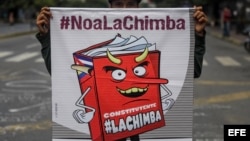 Un hombre sostiene un cartel con una caricatura que representa la Constituyente convocada por Nicolás Maduro.