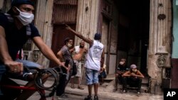 Vecinos conversan en la entrada de un edificio de La Habana. AP Photo/Ramon Espinosa