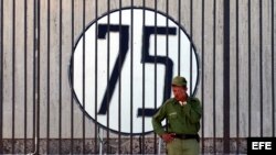 ARCHIVO. Un soldado cubano monta guardia junto a la Oficina de Intereses de Estados Unidos en Cuba, donde se colocó un cartel con un número 75 en solidaridad con los 75 disidentes detenidos en la primavera del 2003.