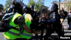 La policía contiene a uno de los manifestantes de los "Chalecos amarillos" en París, abril 20 de 2019.