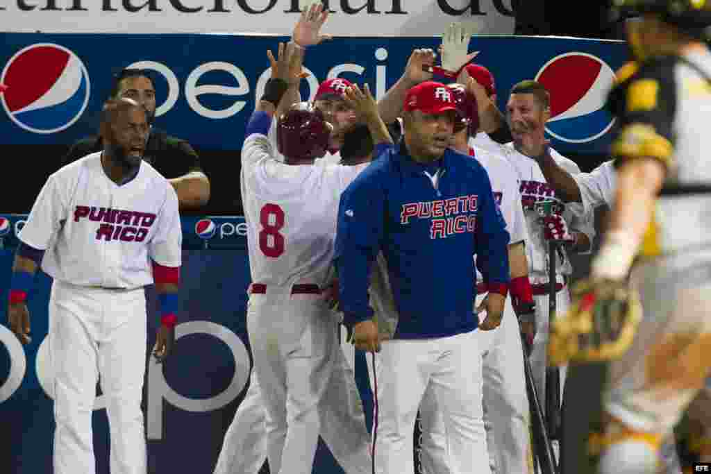 Luis Figueroa (c) de los Indios de Mayagüez de Puerto Rico celebra con sus compañeros de equipo tras anotar una carrera.