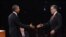 Barack Obama (i), y el candidato republicano, Mitt Romney (d), se saludan previo al primer debate presidencial,  en la Universidad de Denver, Colorado.