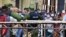 Cubanos se aglomeran en un mercado de La Habana, bajo la vigilancia de agentes de la policía, para comprar alimentos, el 12 de abril del 2020.