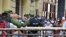 Cubanos se aglomeran en un mercado de La Habana, bajo la vigilancia de agentes de la policía, para comprar alimentos, el 12 de abril del 2020.