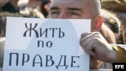 Con un cartel que dice "Basta de mentir", un manifestante muestra su rechazo a la propaganda del Kremlin. 