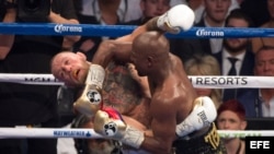 El púgil Floyd Mayweather (d) en acción frente al campeón de artes marciales mixtas Conor McGregor (i).