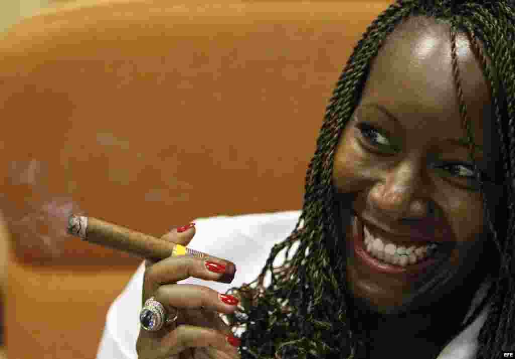Una mujer posa para una foto fumándose un tabaco durante la inauguración del Festival del Habano, en La Habana.