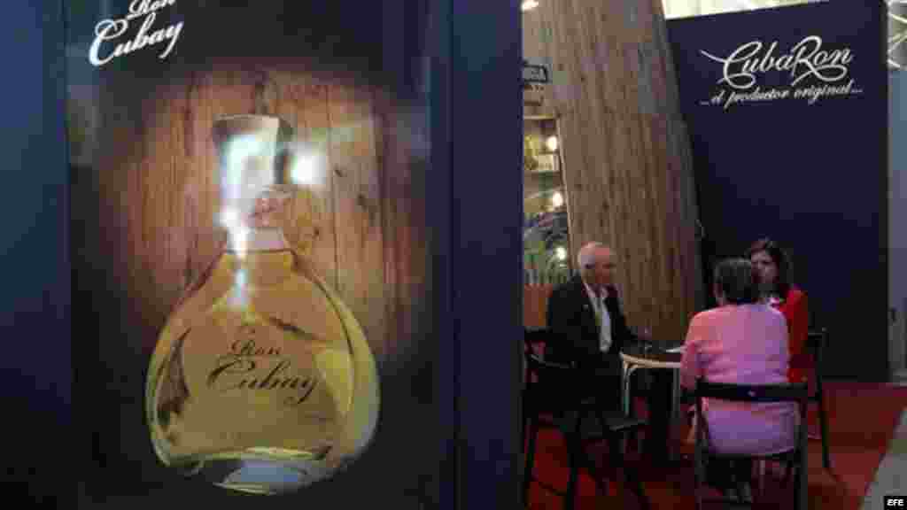 Un grupo de personas habla el stand del fabricante cubano de licores Cuba Ron