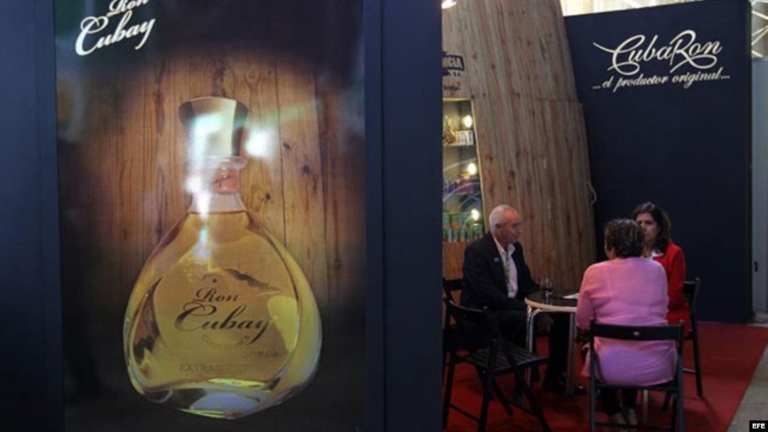 Un grupo de personas habla el stand del fabricante cubano de licores Cuba Ron
