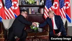 Saludos entre Donald Trump y Kim Jong-Un en una de las salas del Hotel Capella