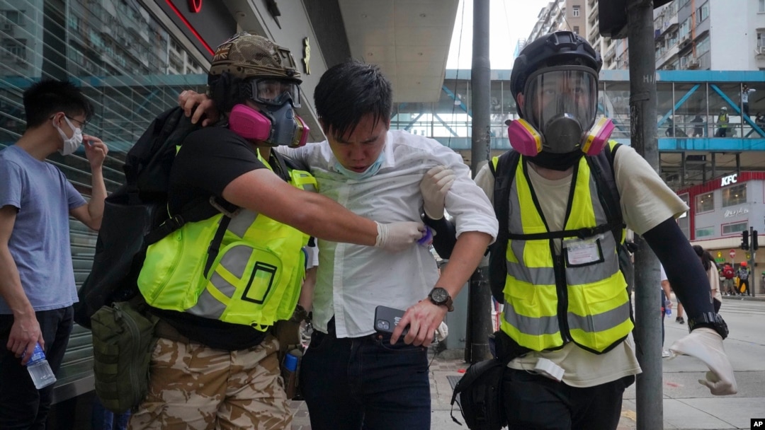 Paramédicos ayudan a un manifestante alcanzado por gas lacrimógeno durante una protesta en Causeway Bay, Hong Kong. (AP/Vincent Yu)