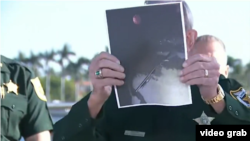 El Sheriff del Condado de Palm Beach, Ric Bradshaw, sostiene una foto del arma que cargaba el hombre abatido en Mar-a-Lago. 