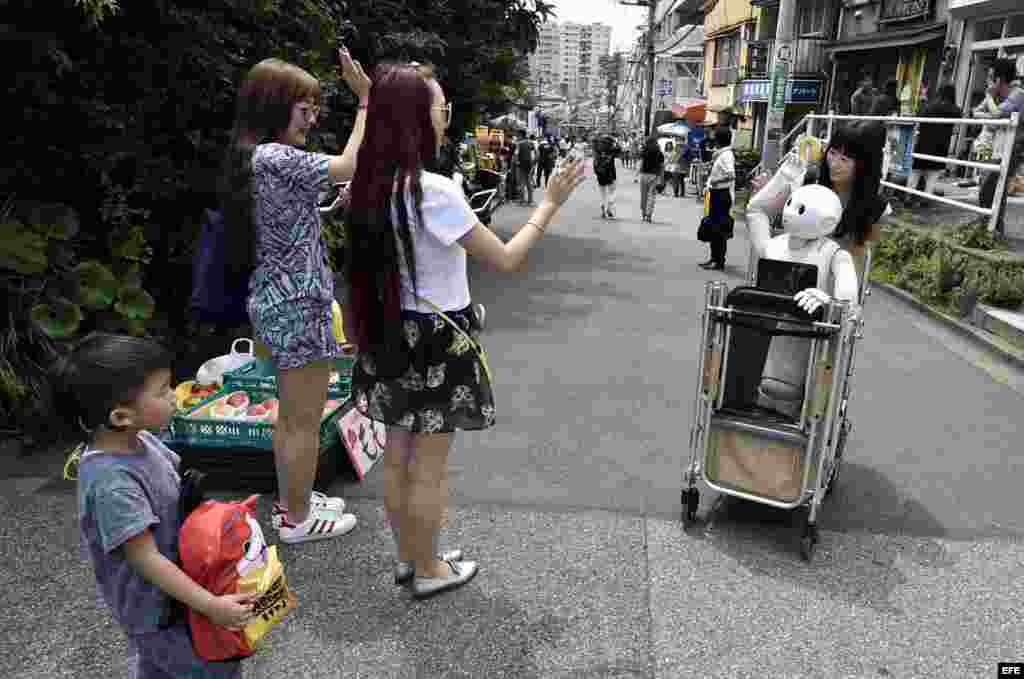 Turistas saludan a Tomoni Ota y Pepper en las calles de Tokio.