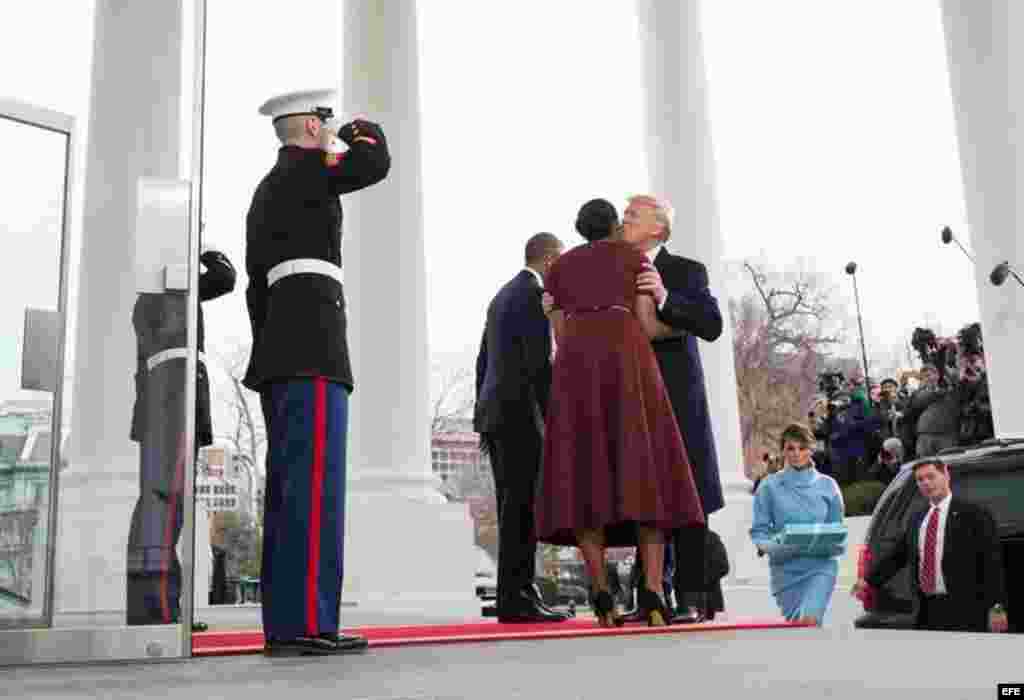 La primera dama Michelle Obama (c) besa al presidente electo, Donald Trump (d), a su llegada a la Casa Blanca.